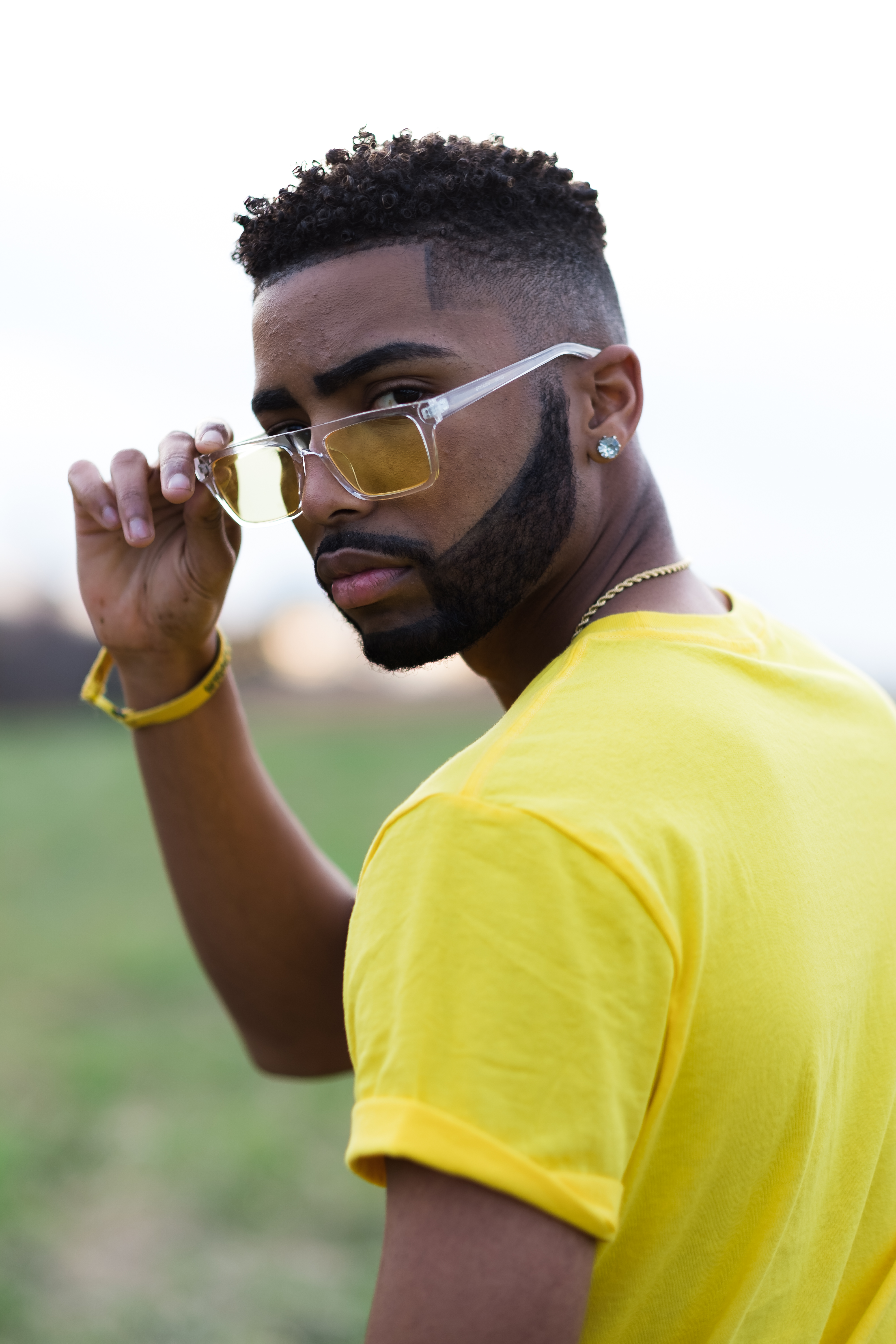 Portrait of a man in yellow shirt and sunglasses looking at the camera
