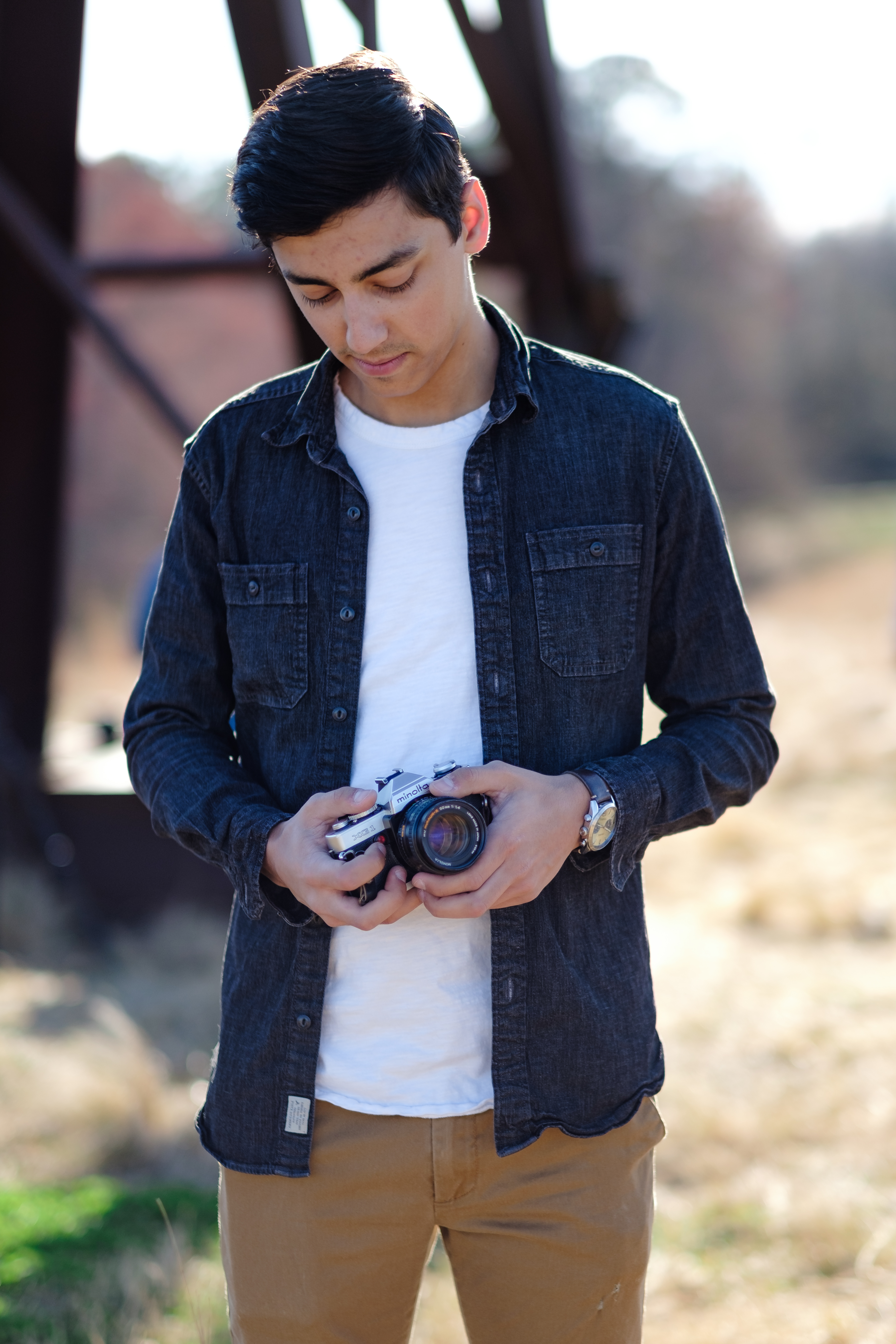 Lifestyle portrait of a man holding a camera outdoors